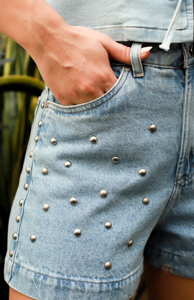 Detalhe de short jeans com tachas